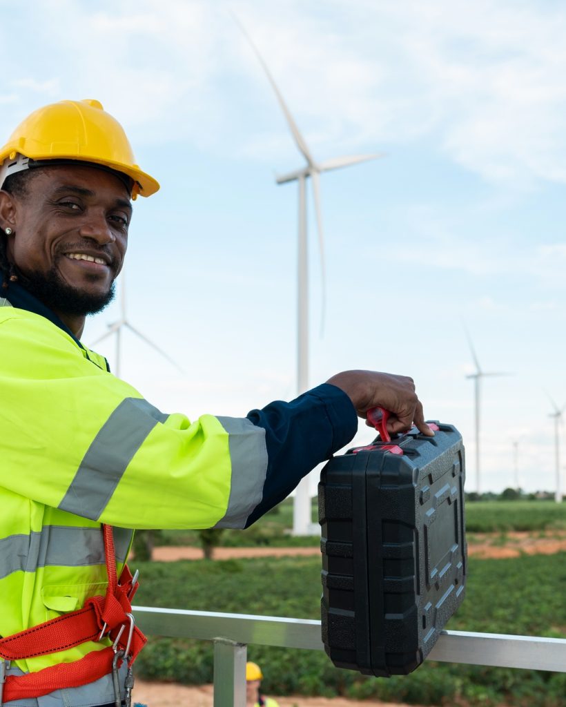 Portrait of smart engineer with protective helmet at electrical turbines field